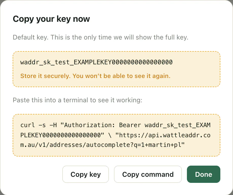 A dialog titled 'Copy your key now' showing an example test key, waddr_sk_test_EXAMPLEKEY, a ready-made curl command, and Copy key, Copy command and Done buttons.